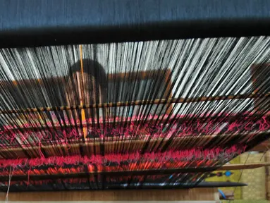 Seorang perajin menenun kain songket di sentral kerajinan songket Patuh, Desa Sukarara, Lombok Tengah, Selasa (13/10). Desa Sukarara menjadi salah satu penghasil kain tenun khas suku Sasak, Lombok. (Liputan6.com/Gempur M Surya)