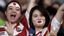 Dua fans wanita dengan wajah di cat bendera Jepang bersorak sebelum pertandingan melawan Rusia pada pembukaan Rugby World Cup Pool A  di Stadion Tokyo (20/9/201). Rugby World Cup diselenggarakan dari 20 September hingga 2 November 2019. (AP Photo/Jae Hong)