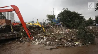 Petugas dengan alat berat mengangkat sampah yang menumpuk di Jembatan Jalan KH Abdullah Syafei, Jakarta, Selasa (6/2). Hingga kini, Dinas Lingkungan Hidup DKI Jakarta telah mengangkut 700 ton sampah. (Liputan6.com/Arya Manggala)