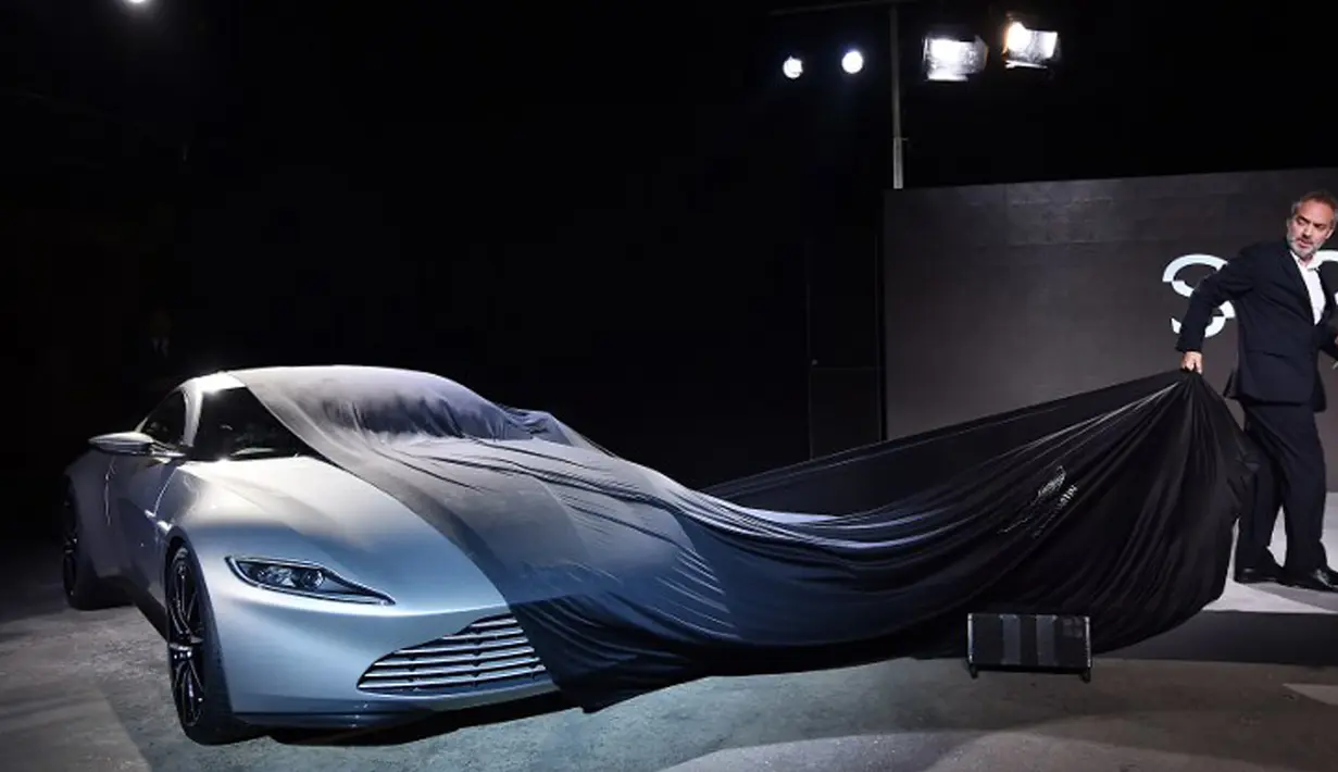 Sam Mendes membuka kain penutup saat memperkenalkan Aston Martin DB10 sebagai mobil James Bond dalam film Spectre di Pinewood Studios, Iver Heath, London (4/12/2014) (Reuters/Ben Stansall)