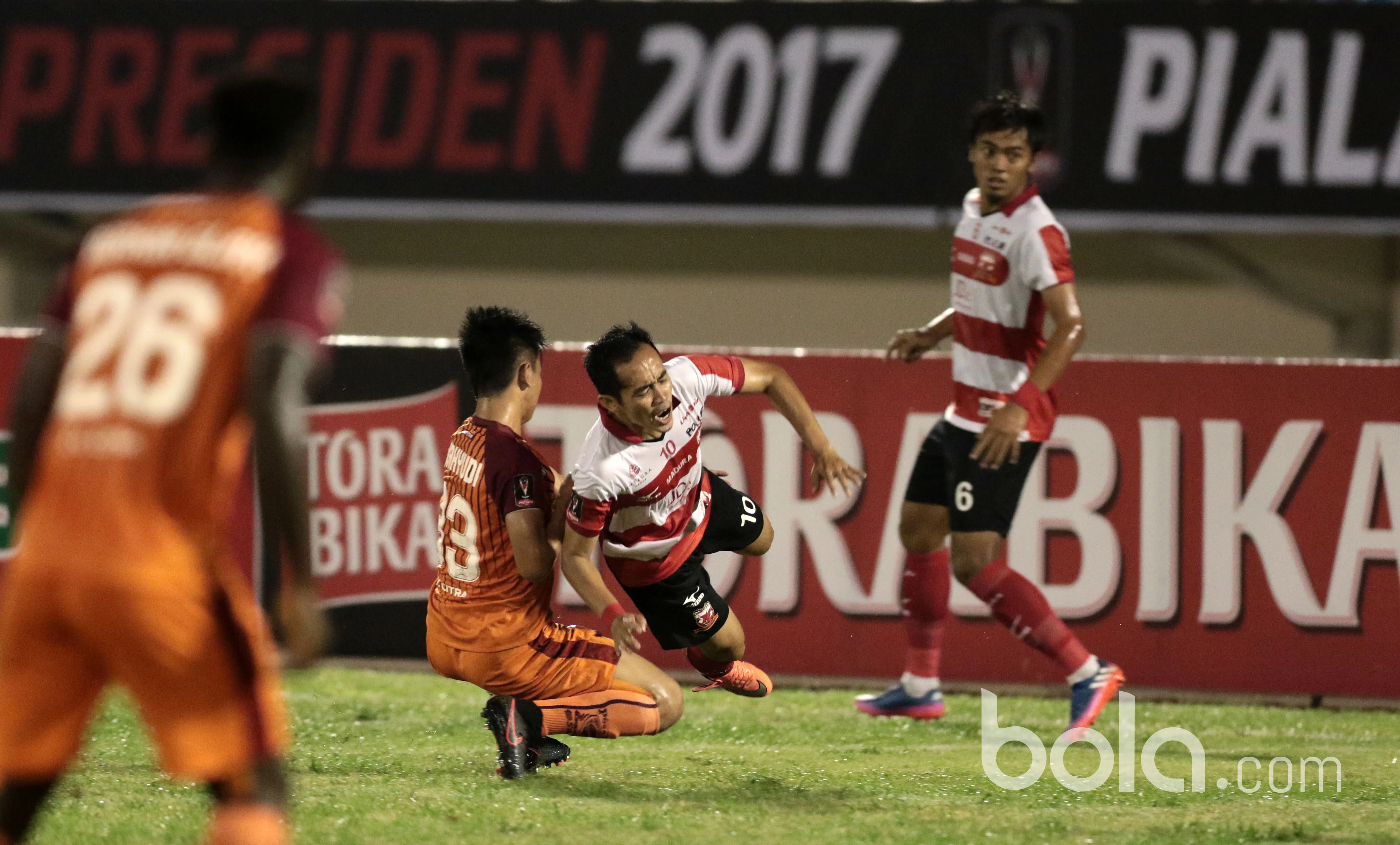 Pemain Madura United, Slamet Nurcahyo (2kanana) terjatuh saat dihadang pemain Pusamania Borneo FC pada babak delapan besar Piala Presiden 2017 di Stadion Manahan, Solo. Jumat (25/2/2017). (Bola.com/Nicklas Hanoatubun)