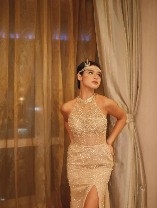 Maria Theodore tampil bak princess dengan sebuah gaun berkilauan tanpa lengan. Dress ini dilapisi payet dan kristal semarak dan memiliki detail high slit. [Foto: Instagram/mariatheodoree]