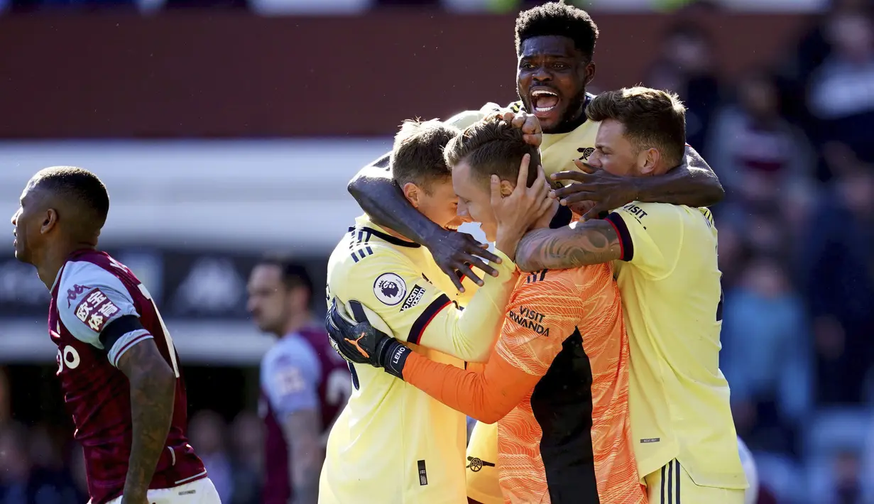 Kiper Arsenal, Bernd Leno (tengah) melakukan selebrasi dengan rekan setimnya setelah melakukan penyelamatan pada fase akhir pertandingan melawan Aston Villa pada lanjutan Liga Inggris di Villa Park, Inggris, Sabtu (19/3/2022). Arsenal menang tipis atas Aston Villa 1-0. (Nick Potts/PA via AP)