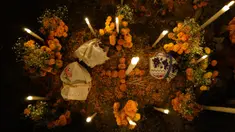 Bunga, persembahan makanan, dan lilin menghiasi makam pada perayaan Hari Kematian di pemakaman Arocutin, Michoacan, Meksiko, 1 November 2021. Pada Hari Kematian, kerabat menghabiskan malam di samping makam orang yang mereka cintai. (AP Photo/Eduardo Verdugo)