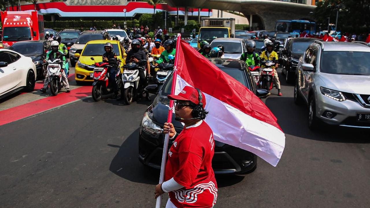 Seorang pria membawa bendera merah putih saat peringatan HUT ke-79 Kemerdekaan RI di kawasan Bundaran HI, Jakarta, Sabtu (17/8/2024). Peringatan HUT ke-79 Kemerdekaan RI turut menarik perhatian para pengendara dan pejalan kaki yang melintas di kawasan Bun