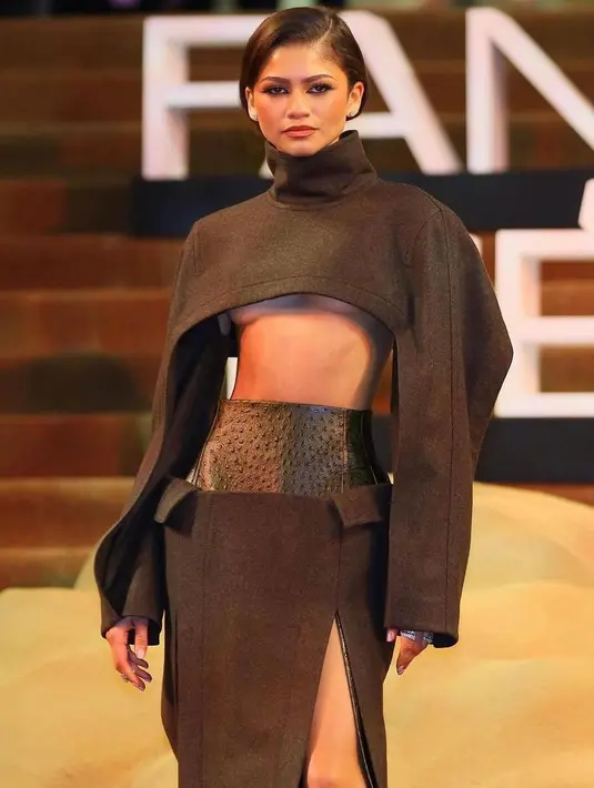 Sedangkan di red carpet yang diselenggarakan di Meksiko, Zendaya tampil tak kalah totalitas. Ia memilih fully custom berwarna Mocha Monochrome dari Bottega Veneta yang dirancang oleh Matthieu Blazy. Desain outfit Zendaya di sini terdiri dari supper cropped, long-sleeved top, dan thigh-high skirt slit. [Foto: Instagram/dunemovie]
