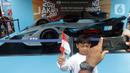 Seorang anak berfoto dengan latar replika mobil Formula E yang dipamerkan di Kawasan Bundaran Hotel Indonesia, Jakarta, Minggu (29/5/2022). Replika mobil balap ramah lingkungan ini dipamerkan untuk mengkampanyekan perhelatan Formula E yang akan digelar 4 Juni mendatang. (Liputan6.com/Helmi Fithriansyah)