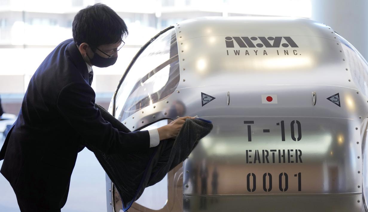 Seorang staf membersihkan kabin dua tempat duduk yang menurut perusahaan rintisan mampu naik hingga ketinggian 15 mil, yang kira-kira berada di tengah stratosfer, saat konferensi pers di Tokyo, Selasa, 21 Februari 2023. Perusahaan startup Jepang mengumumkan rencana Selasa untuk meluncurkan penerbangan balon pengamatan ruang angkasa komersial yang diharapkan akan membawa pengalaman yang sangat mahal ke bumi. (Foto AP/Eugene Hoshiko)