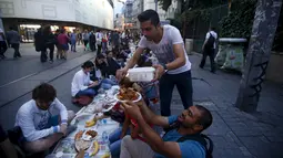 Warga saat bersiap menunggu waktu berbuka puasa pada hari pertama bulan suci Ramadan, di Taksim Square, Istanbul, Turki, Kamis (18/6/2015). Tradisi buka puasa beramai-ramai sudah menjadi tradisi di negara tersebut. (REUTERS/Osman Orsal)