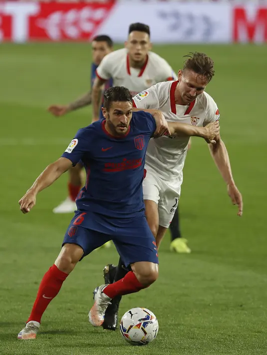 Gelandang Atletico Madrid, Koke (kiri) dan penyerang Sevilla, Luuk de Jong berebut bola pada pekan ke-29 Liga Spanyol di Wanda Metropolitano, Madrid, Senin (5/4/2021) dini hari WIB. Tandang ke markas Sevilla, Atletico Madrid kalah dengan skor 0-1. (AP Photo/Angel Fernandez)