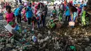 Anak-anak memungut sampah yang berserakan di sekitar kawasan pantai di Surabaya, Jawa Timur, Sabtu (21/9/2019).Aksi tersebut sebagai wujud kepedulian terhadap kebersihan lingkungan sekaligus dalam rangka memperingati World Cleanup Day 2019.  (JUNI KRISWANTO / AFP)