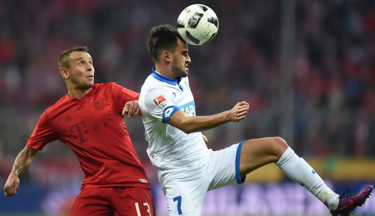 Aksi pemain Bayern Munich, Rafinha (kiri) saat menghadang pemain Hoffenheim, Lukas Rupp pada laga Bundesliga di Stadion Alianz Arena, Munich, (5/11/2016). (AFP/Christof Stache