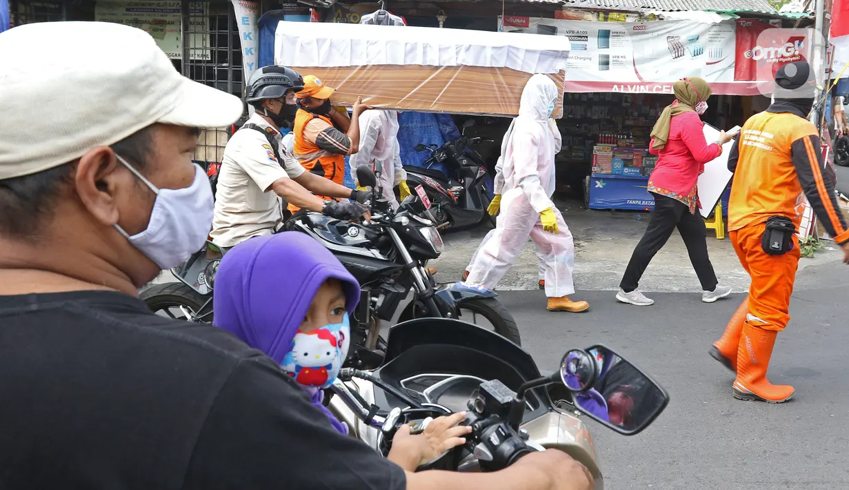 Petugas gabungan dari Kecamatan Cilandak mengarak instalasi peti mati jenazah Covid-19 di kawasan perumahan Fatmawati, Jakarta, Jumat (28/8/2020). Sosialisasi tersebut dilakukan untuk memberikan peringatan kepada warga akan bahaya penularan virus Covid-19. (Liputan6.com/Herman Zakharia)