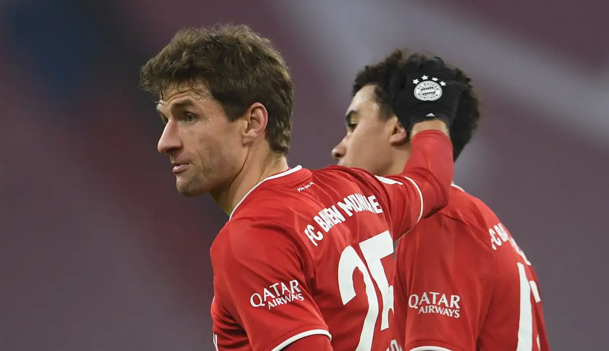 Dua pencetak gol Bayern Munich, striker Thomas Mueller (kiri) dan gelandang Jamal Musiala merayakan hasil imbang 3-3 melawan RB Leipzig usai laga lanjutan Liga Jerman pekan ke-10 di Allianz Arena, Sabtu (5/12/2020). (AFP/Andreas Gebert/Pool)