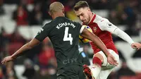 Bek Manchester City, Vincent Kompany berebut bola dengan gelandang Arsenal, Aaron Ramsey pada laga pekan ke-28 Premier League di Emirates Stadium,  Jumat (2/3). Manchester City mempermalukan Arsenal dengan skor telak 3-0. (Glyn KIRK/AFP)