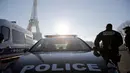 Seorang petugas polisi berpatroli di dekat Menara Eiffel di Paris,  Senin (30/12/2019). Pemerintah Prancis akan mengerahkan 100.000 petugas polisi untuk mengamankan ruang publik pada perayaan malam Tahun Baru di tengah aksi mogok yang sedang berlangsung. (AP/Christophe Ena)