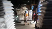 Pekerja memanggul karung Beras di pasar induk Cipinang, Jakarta, Selasa (27/12). Kecukupan kebutuhan tersebut diharapkan bisa menahan laju kenaikan harga barang pokok. (Liputan6.com/Angga Yuniar)