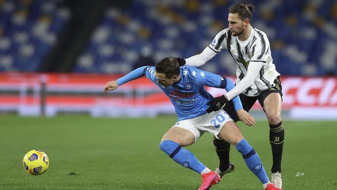 Pemain Napoli Piotr Zielinski memperebutkan bola dengan Adrien Rabiot dari Juventus, selama pertandingan sepak bola Liga Italia di stadion Diego Armando Maradona di Naples, Italia, Sabtu, 13 Februari 2021. (Alessandro Garofalo / LaPresse melalui AP)