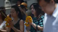 Sejumlah warga melakukan doa bersama di sekitar lokasi kejadian ledakan bom di Thailand), Bangkok, Rabu (19/8/2015). Peristiwa tersebut dikabarkan telah menewaskan sekitar 20 orang. (AFP Photo/Jerome Taylor)