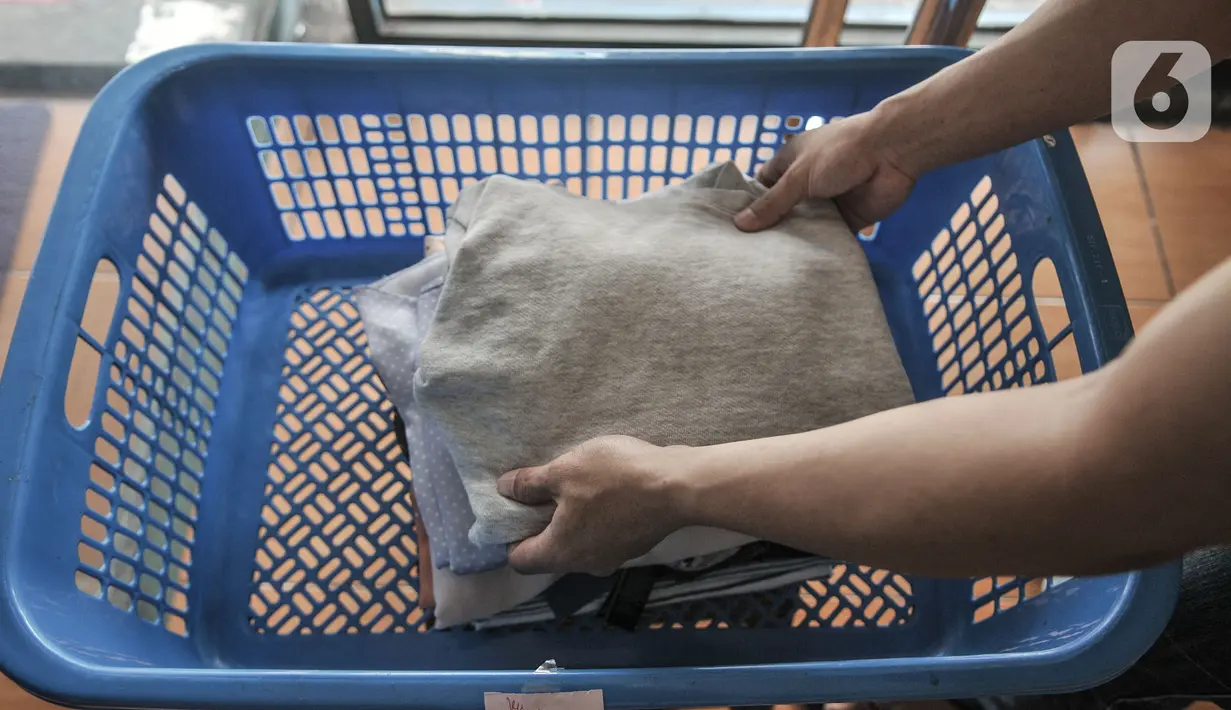 Pekerja merapikan pakaian pelanggan yang dititipkan di Jaksa Clean Coin Laundry, Jalan Jaksa, Jakarta, Kamis (1/4/2021). Seorang pekerja mengungkapkan sebelum pandemi biasanya menerima rata-rata 10 pelanggan dalam sehari, namun kini merosot menjadi 4 pelanggan per hari. (merdeka.com/Iqbal S Nugroho)
