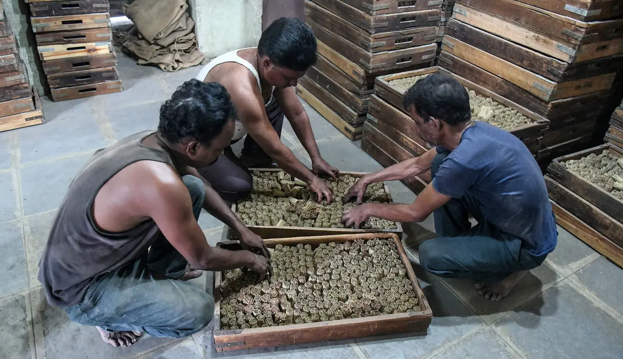 Pekerja menata rokok linting atau beedi pada wadah sebelum dikeringkan ke dalam tungku di sebuah pabrik di Nizamabad, India, 10 Oktober 2019. Penjualan rokok linting ala India ini telah mengalahkan rokok filter dengan perbandingan 8:1. (NOAH SEELAM/AFP)