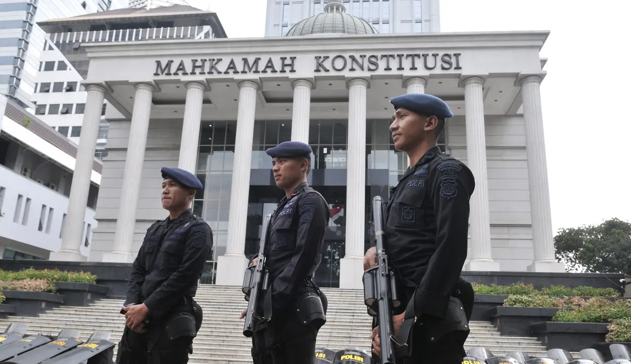 Personel kepolisian saat berjaga di depan Gedung Mahkamah Konstitusi (MK), Jakarta, Rabu (26/6/2019). Penjagaan di sekitar Gedung MK guna mengantisipasi hal yang tidak diinginkan jelang sidang putusan kasus sengketa Pilpres 2019. (merdeka.com/Iqbal S. Nugroho)