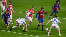 Penyerang Barcelona, Antoine Griezmann membawa bola dari kawalan para pemain Deportivo Alaves pada pertandinga La Liga Spanyol di stadion Camp Nou, Spanyol, Minggu (14/2/2021). Kemenangan  tersebut  membawa Barcelona meraih kemenangan ke-7 secara beruntun di Liga Spanyol. (AP Photo/Joan Monfort)