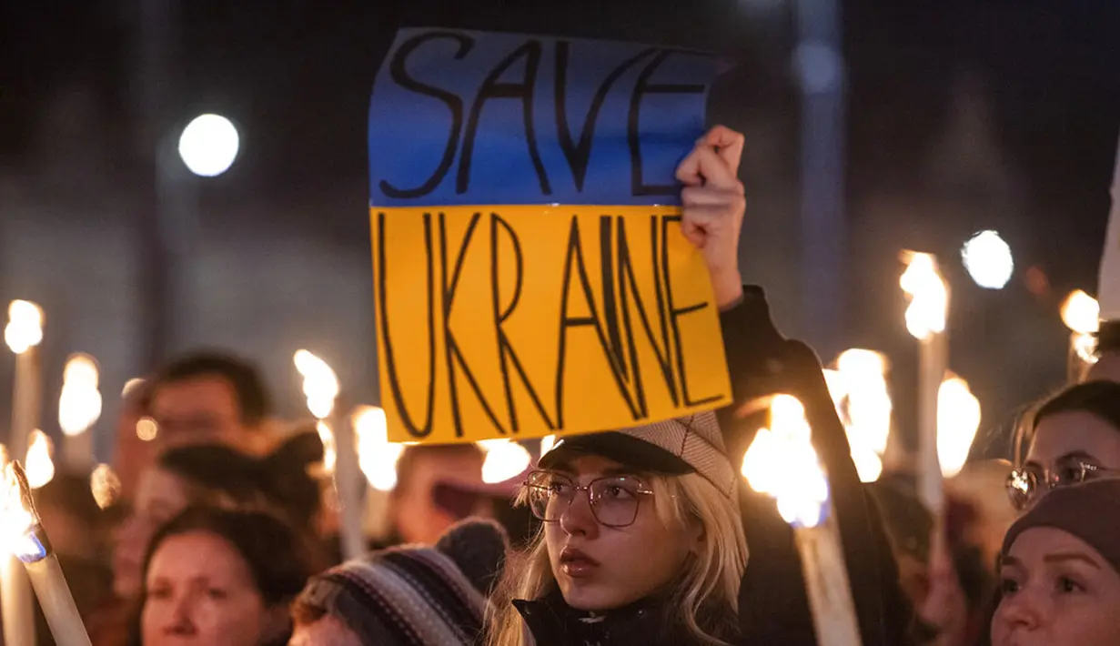 Seorang wanita memegang spanduk saat demonstrasi untuk Ukraina yang diselenggarakan oleh Greenpeace di Heroes Square, Budapest, Hungaria, 9 Maret 2022. Lebih dari 1,5 juta orang telah menyeberang dari Ukraina ke negara-negara tetangga. (AP Photo/Anna Szilagyi)