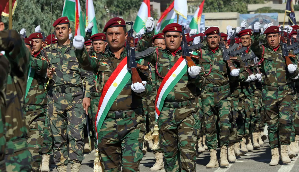 Perwira Peshmerga berbaris dalam formasi saat mengambil bagian dalam upacara kelulusan di Kota Soran, Irak, Rabu (16/10/2019). Latihan pasukan bersenjata Kurdi tersebut dilakukan sekitar 100 kilometer timur laut ibu kota otonomi wilayah Kurdi di Irak, Arbil. (SAFIN HAMED/AFP)