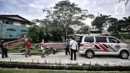 Pekerja membawa peti jenazah yang selesai dibuat untuk dipindahkan ke ambulans di TPU Pondok Kelapa, Jakarta, Selasa (13/7/2021). Berbanding terbalik pada masa sebelum Lebaran, dalam sehari pekerja hanya memproduksi 10-15 peti jenazah. (merdeka.com/Iqbal S Nugroho)