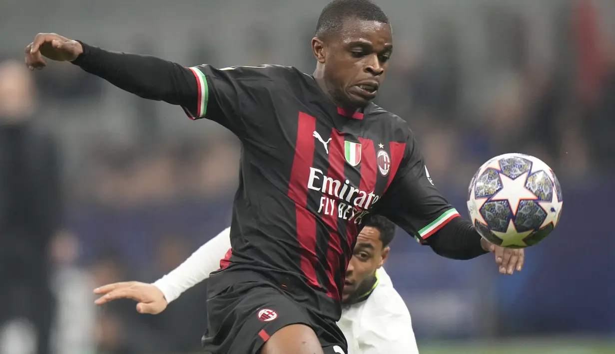 Bek AC Milan, Pierre Kalulu mengejar bola melewati pemain Tottenham, Arnaut Danjuma selama pertandingan leg pertama babak 16 besar Liga Champions di stadion San Siro di Milan, Italia, Rabu (15/2/2023). AC Milan menang tipis atas Tottenham dengan skor 1-0. (AP Photo/Luca Bruno)