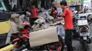 Pekerja membungkus sepeda motor yang akan dikirim di Stasiun Pasar Senen, Jakarta, Selasa (5/6). Jasa pengiriman motor ke daerah meningkat dua kali lipat jelang arus mudik dan Hari Raya Idulfitri 2018. (Liputan6.com/Arya Manggala)