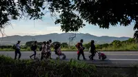 Imigran Honduras mendorong kereta bayi dalam perjalanannya menuju Amerika Serikat di Oaxaca, Meksiko, 29 Oktober 2018. Kereta dorong bayi tak hanya untuk balita mereka, tetapi juga dapat digunakan untuk membawa barang-barang. (Guillermo Arias/AFP)