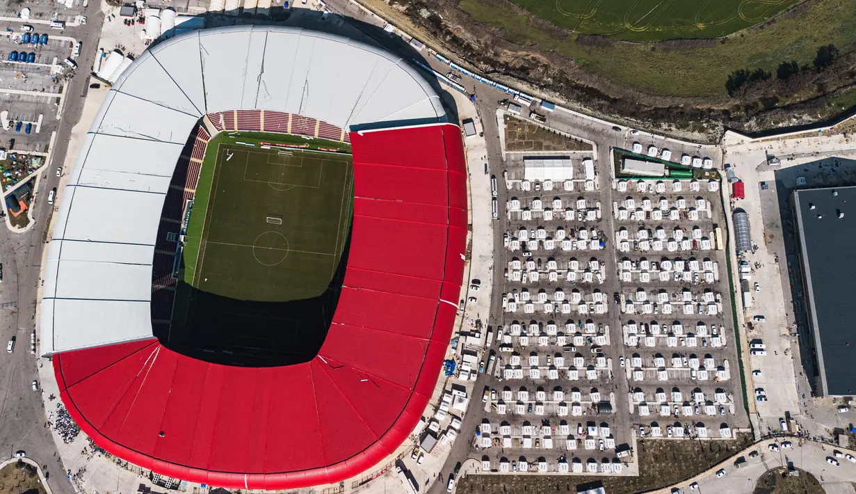 Foto udara menunjukkan deretan tenda pengungsi di sekitar Stadion New Hatay di Antakya, Turki Selatan, pada tanggal 22 Februari 2023. Gempa berkekuatan 6,4 magnitudo kembali mengguncang provinsi selatan Turki, Hatay, dan Suriah Utara, menewaskan enam orang dan memicu kepanikan baru setelah gempa besar pada 6 Februari lalu yang menewaskan hampir 45.000 orang di kedua negara tersebut. (Sameer Al-DOUMY/AFP)