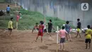 Sejumlah anak bermain sepak bola di sebuah lahan kosong di Pinggir Banjir Kanal Barat, Jakarta, Selasa (12/10/2021). Untuk mencari kesenangan, anak-anak memanfaatkan lahan pinggir BKB meski saat ini juga masih bahaya karena pandemi corona. (Liputan6.com/Johan Tallo)