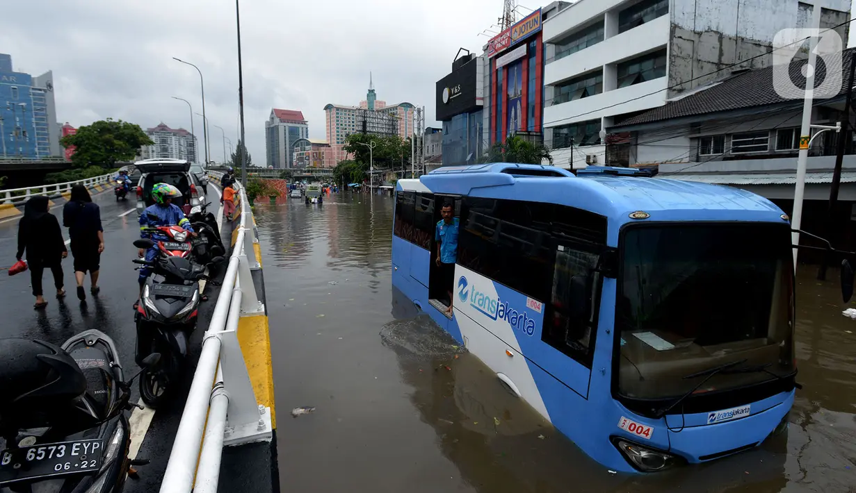 Bus transjakarta terendam banjir di Jalan Raya Daan Mogot, Jakarta, Rabu (1/1/2020). Hujan yang turun saat malam pergantian tahun baru 2019-2020 menyebabkan sejumlah titik jalan terputus di kawasan Grogol terendam banjir. (merdeka.com/Imam Buhori)
