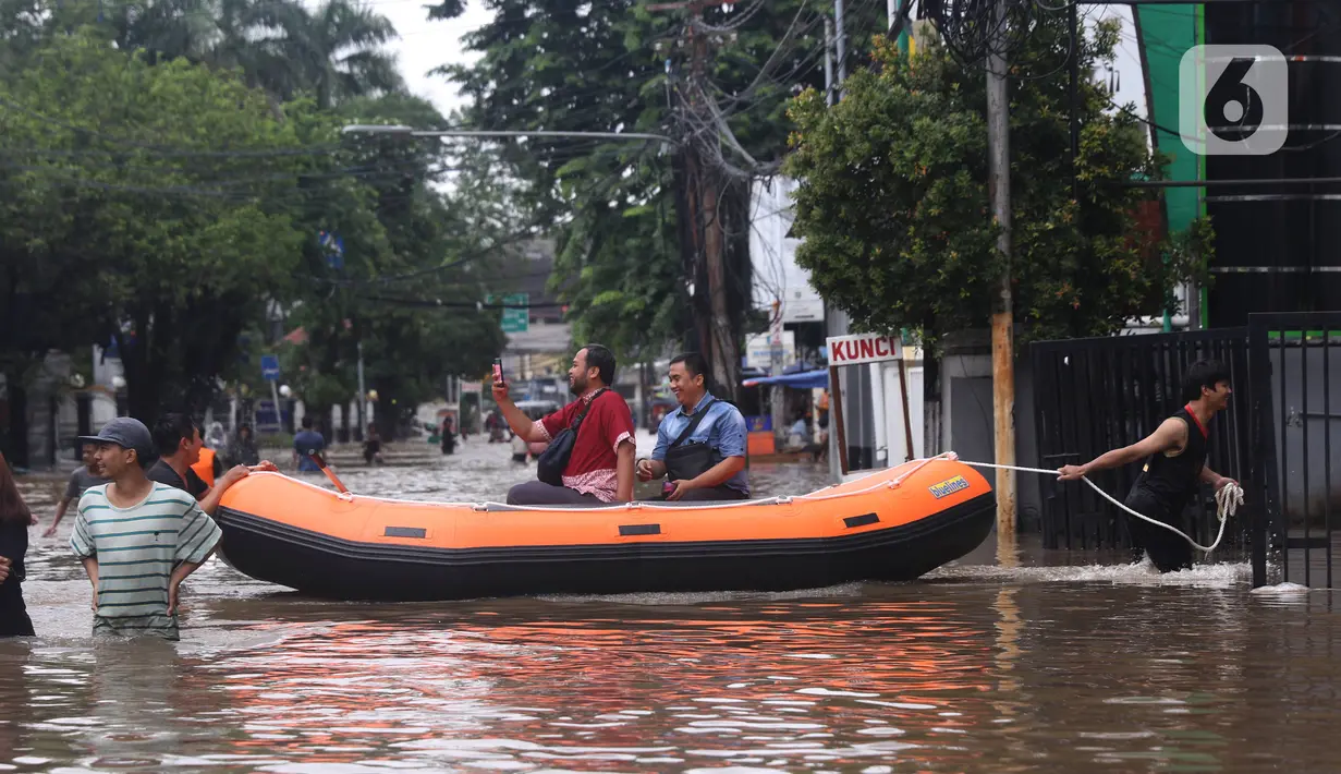 Warga menaiki perahu karet melintasi banjir yang merendam kawasan Benhil, Jakarta, Selasa (25/2/2020). Hujan yang mengguyur wilayah tersebut membuat air sungai meluap sehingga menyebabkan Banjir setinggi pinggang orang dewasa. (Liputan6.com/Angga Yuniar)