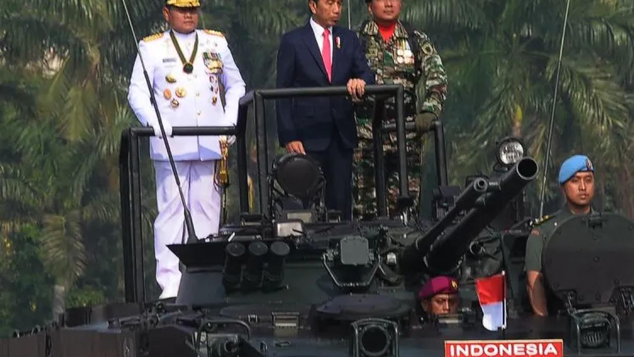 Di atas atas tank itu, Jokowi tampak didampingi Panglima TNI Laksamana Yudo Margono.<br>