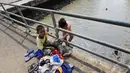 Seorang bocah hendak turun ke kali bergabung bersama kawan-kawannya yang telah berenang. Sedangkan seorang bocah lagi menunggu di atas menjaga baju kawannya (Liputan6.com/Faizal Fanani).