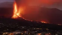 Lava mengalir dari gunung berapi saat terus meletus di pulau Canary La Palma, Spanyol, Selasa (26/10/2021). Aliran lava baru telah muncul setelah runtuhnya sebagian kawah dan mengancam akan menelan daerah yang sebelumnya tidak terpengaruh. (AP Photo/Emilio Morenatti)