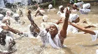 Pengikut Voodoo Haiti mandi di kolam suci selama upacara Voodoo di Souvenance, Haiti (4/1). Hingga kini Voodoo adalah salah satu dari tiga agama yang diakui di Haiti. (AFP/Hector Retamal)