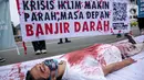 Aktivis melakukan teatrikal dengan menyiramkan darah di tubuhnya saat aksi serentak desak Presiden Jokowi deklarasikan Darurat Iklim di kawasan Patung Kuda, Jakarta, Jumat (19/3/2021). Aksi serentak di beberapa lokasi itu untuk menuntut deklarasi darurat iklim. (Liputan6.com/Faizal Fanani)