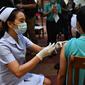Seorang perawat menyuntikkan vaksin Covid-19 CoronaVac dari Sinovac di Institut Penyakit Menular Bamrasnaradura di Bangkok, Thailand, Minggu (28/2/2021). Tenaga medis dan relawan kesehatan menjadi golongan pertama yang menerima vaksin Covid-19 tersebut. (Lillian SUWANRUMPHA/AFP)