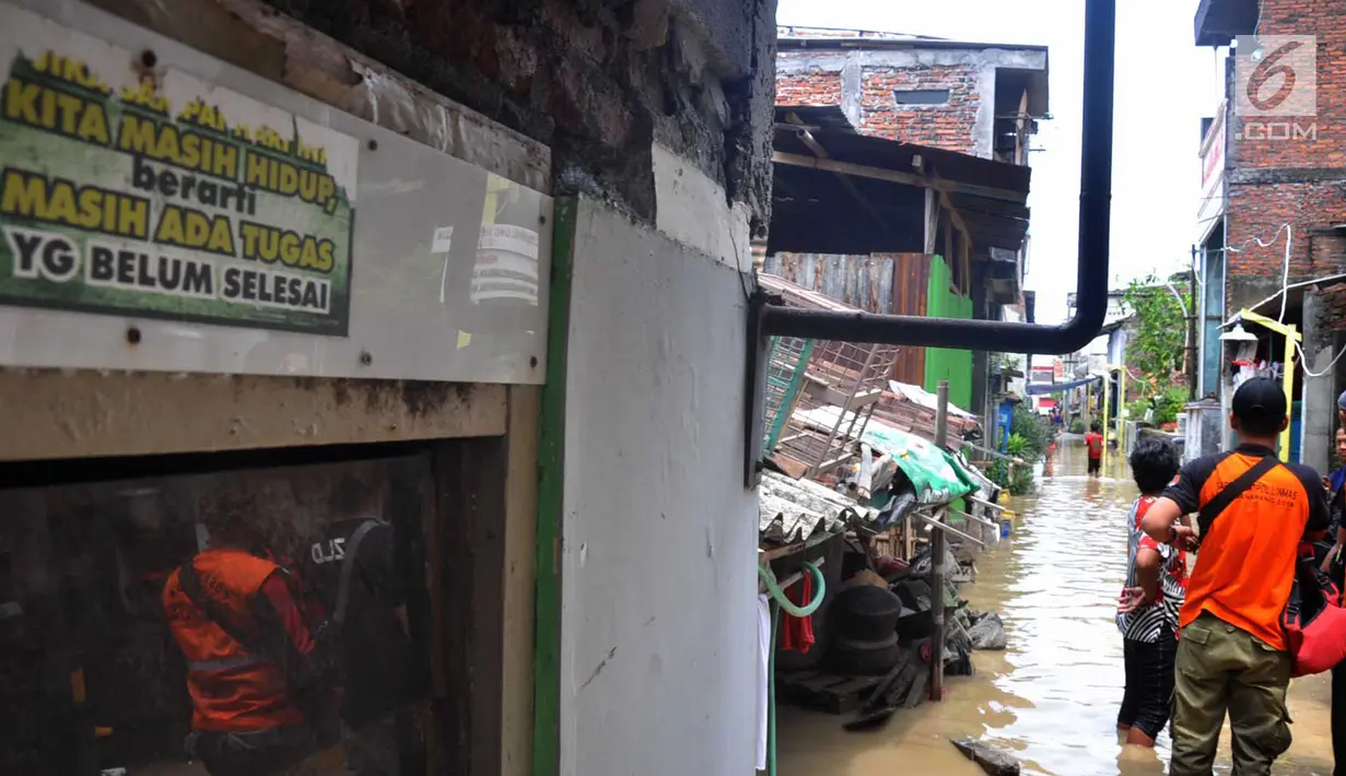 Petugas mengecek perumahan yang tergenang banjir di kawasan Sawah besar Semarang, Jawa Tengah, Sabtu (8/12). Tingginya curah hujan dan banyaknya tumpukan sampah diduga menjadi penyebab jebolnya tanggul. (Liputan6.com/Gholib)