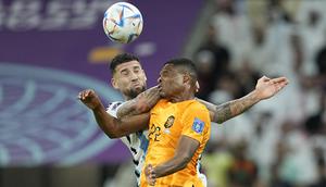 Pemain Timnas Belanda, Denzel Dumfries (kanan) berduel udara dengan pemain Timnas Argentina, Nicolas Otamendi dalam laga babak perempatfinal Piala Dunia 2022 di Lusail Stadium, Lusail, Qatar, Sabtu (10/12/2022) dini hari WIB. (AP/Ebrahim Noroozi)