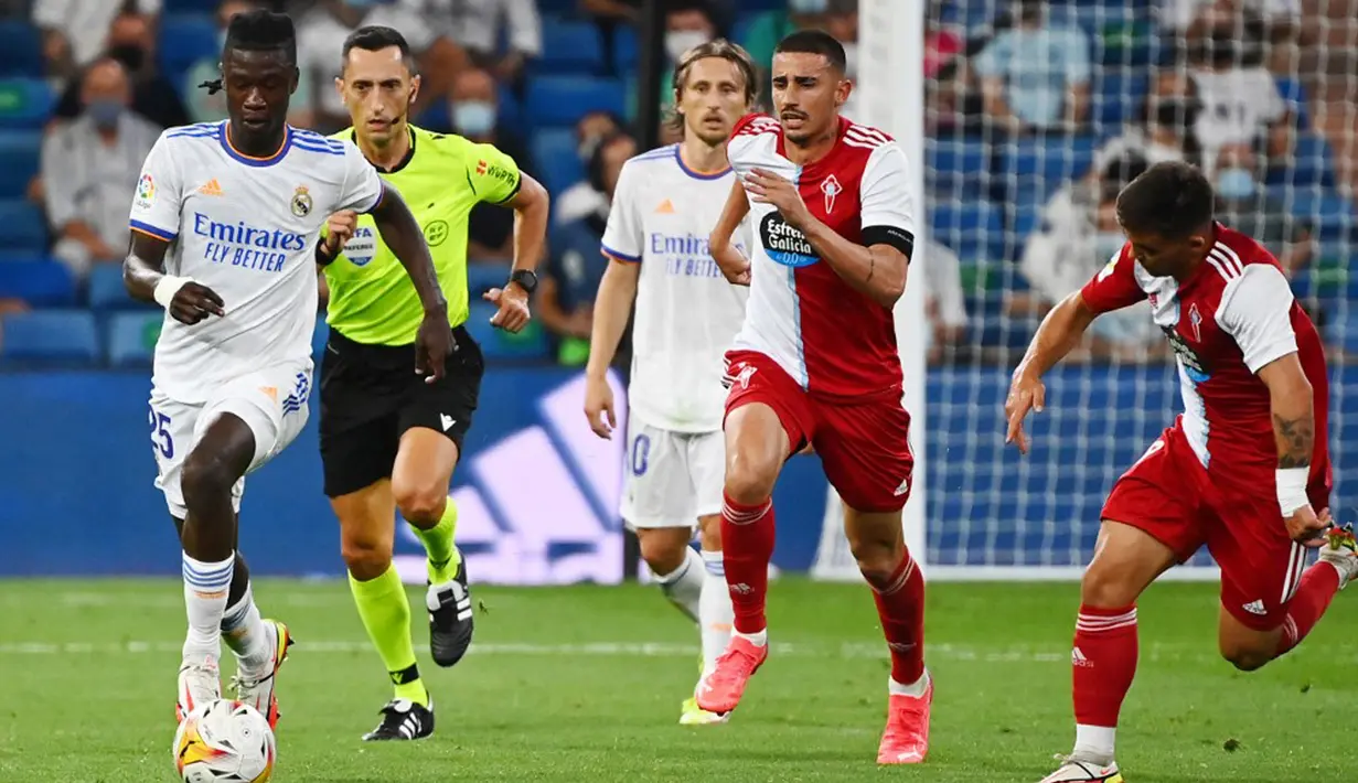 Pemain Real Madrid Eduardo Camavinga (kiri) berlari dengan bola saat melawan Celta Vigo pada pertandingan Liga Spanyol di Stadion Santiago Bernabeu, Madrid, Spanyol, 12 September 2021. Karim Benzema mencetak hattrick saat Real Madrid mengalahkan Celta Vigo 5-2. (GABRIEL BOUYS/AFP)