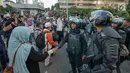 Sejumlah peserta aksi bersalaman dengan Polisi dari kesatuan Brimob saat gelar doa bersama di depan kantor Bawaslu, Jakarta, Jumat (24/5/2019). Mereka datang untuk mendoakan para demonstran yang meninggal saat aksi 21-22 Mei, pasca hasil penghitungan suara Pemilu 2019. (Liputan6.com/Herman Zakharia)