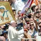 Paus Fransiskus menyapa jemaah seusai Kanonisasi Bunda Teresa di St. Peter, Vatikan, Minggu (4/9). Paus Fransiskus, secara resmi menobatkan Bunda Teresa sebagai santa atau orang suci terkait kerja kemanusiaannya di Kalkuta, India. (Andreas Solaro/AFP)