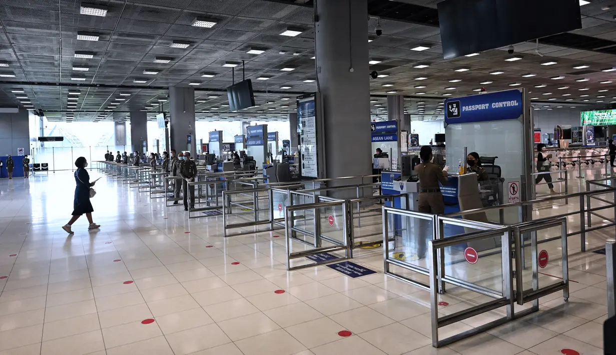 Petugas imigrasi menunggu di jalur imigrasi Bandara Internasional Suvarnabhumi saat mereka berlatih prosedur untuk pembukaan kembali Thailand, di Bangkok, Rabu (27/10/2021). Mulai 1 November, Thailand dibuka kembali tanpa persyaratan karantina untuk yang divaksinasi penuh. (Lillian SUWANRUMPHA/AFP)