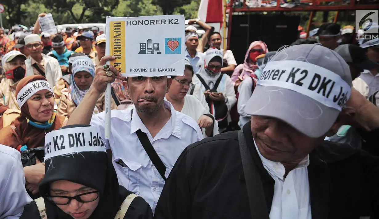 Pegawai honorer DKI Jakarta membawa kertas bertuliskan aspirasi saat menggelar demo di Balai Kota, Jakarta, Rabu (26/9). Peraturan Menteri PAN-RB (Permenpan) Nomor 36 dan 37 tahun 2018. (Liputan6.com/Faizal Fanani)